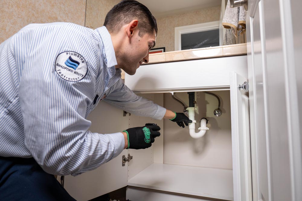 person checking sink pipe